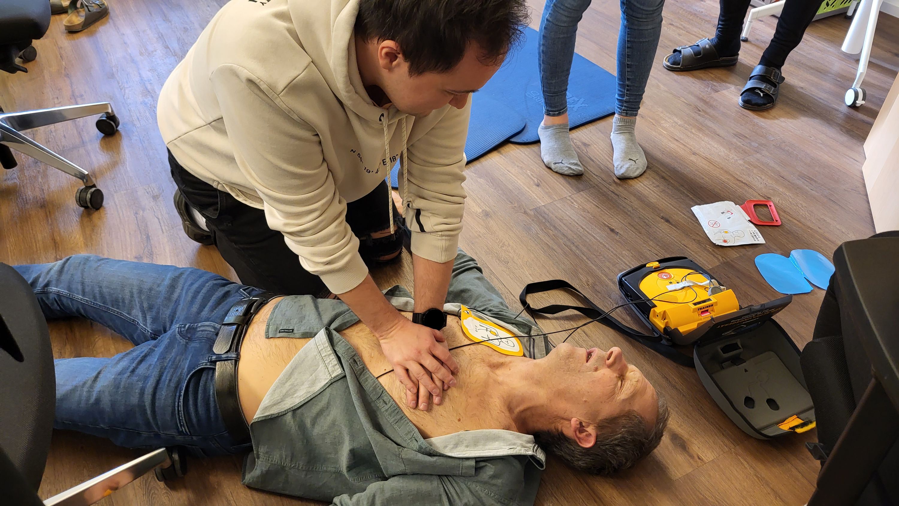 Mitarbeiter erlernt den Umgang mit einem Test-Defibrillator.